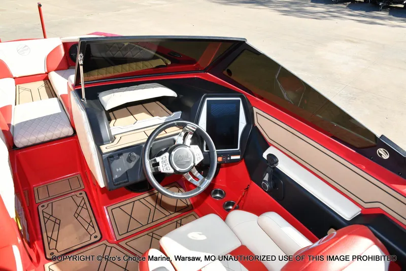 Slide: The Image of 2022 Tigé 24RZX boat interior with red and beige seating, modern dashboard, and steering wheel. - 21