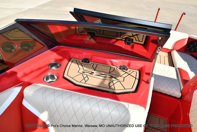 Slide: The Image of 2022 Tigé 24RZX boat interior with red and white seating, cup holders, and RZX logo mat. - 25