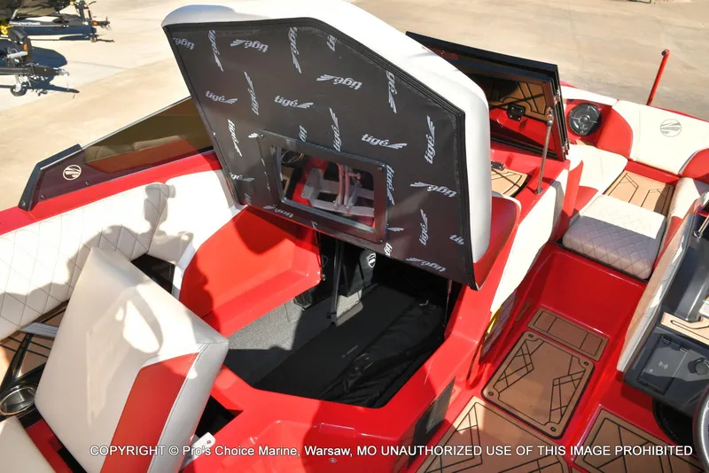 Slide: The Image of 2022 Tigé 24RZX boat interior with red and white seating, open storage compartment. - 27