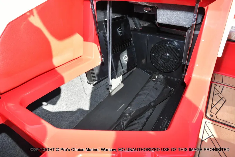 Slide: The Image of 2022 Tigé 24RZX boat interior storage compartment with red seating and speaker system. - 28