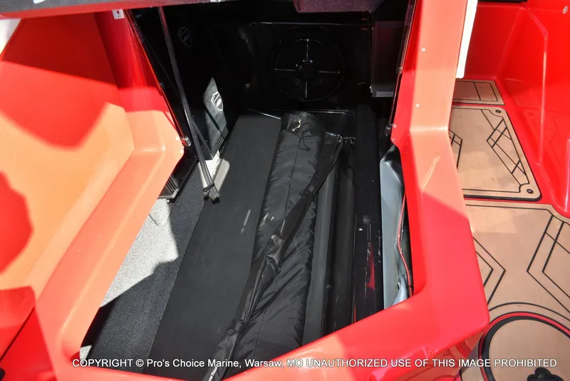 Slide: The Image of Interior storage compartment of 2022 Tigé 24RZX boat, featuring red and black design. - 29