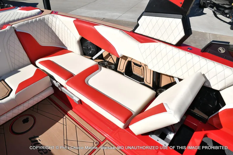 Slide: The Image of 2022 Tigé 24RZX boat interior with red and white seating, cup holders, and quilted design. - 30