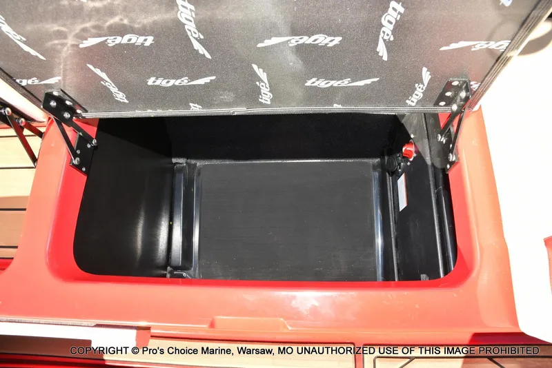 Slide: The Image of Open storage compartment in 2022 Tigé 24RZX boat, featuring branded interior lid. - 32
