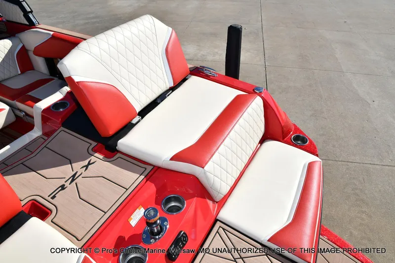 Slide: The Image of 2022 Tigé 24RZX boat interior with red and white seating, cup holders, and RZX logo mat. - 40