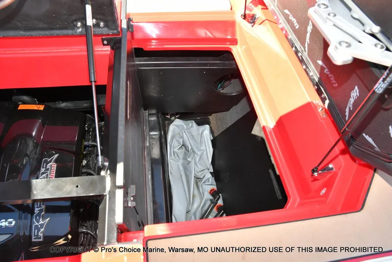 Slide: The Image of 2022 Tigé 24RZX boat storage compartment with engine view, featuring red and beige interior. - 48