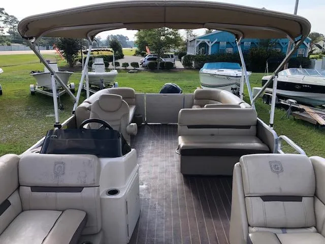Slide: The Image of 2020 Sweetwater 2286 pontoon boat with spacious seating and canopy, parked on grass. - 8