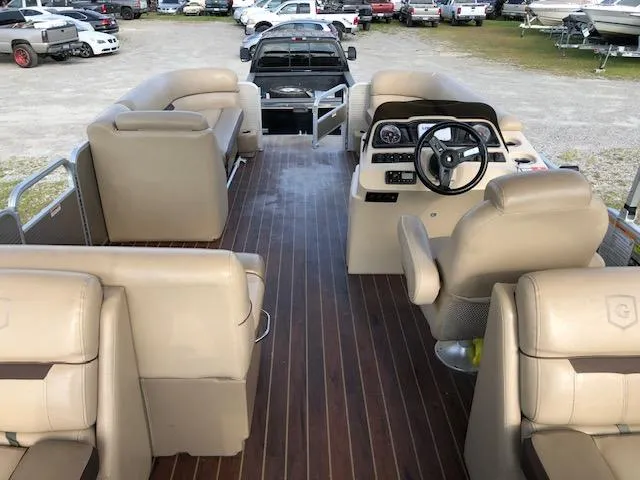 Slide: The Image of 2020 Sweetwater 2286 pontoon boat interior with beige seating and wood-style flooring. - 9