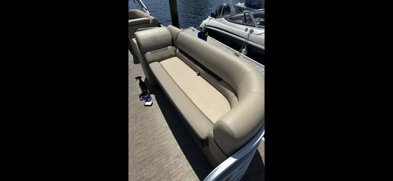 Slide: The Image of 2023 Sweetwater SW 2286 SB pontoon boat with beige seating by the water. - 6