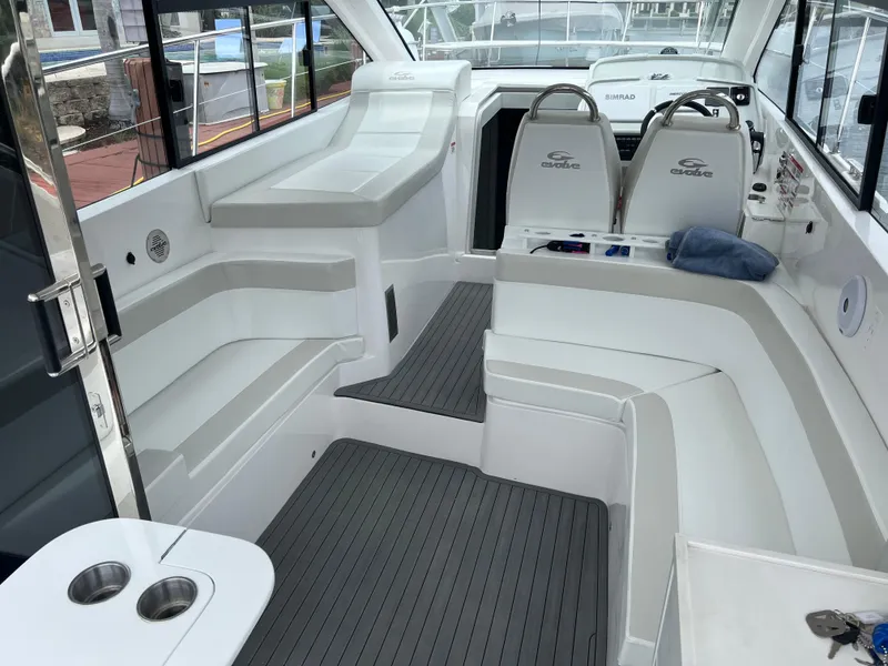Slide: The Image of Luxury Evolve 400HT yacht deck with seating and table, 2021 model, docked by the water. - 6
