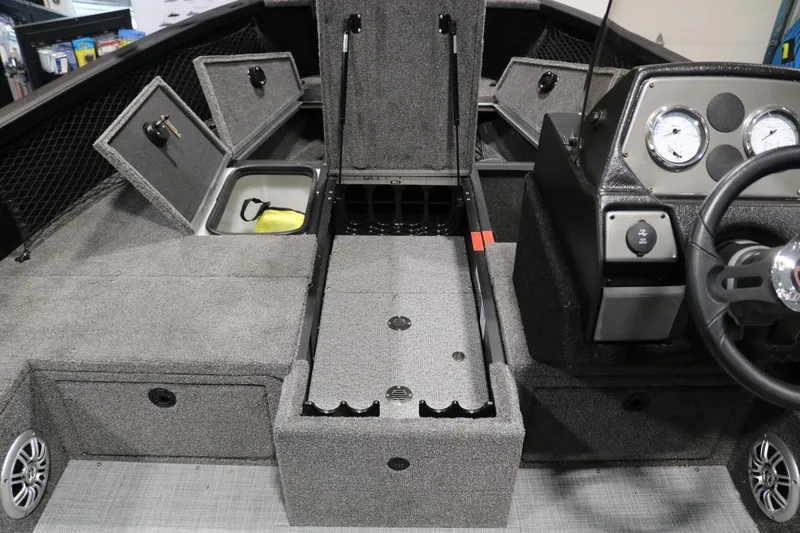 Slide: The Image of 2023 Alumacraft Competitor 185 CS boat interior with storage compartments and steering console. - 10