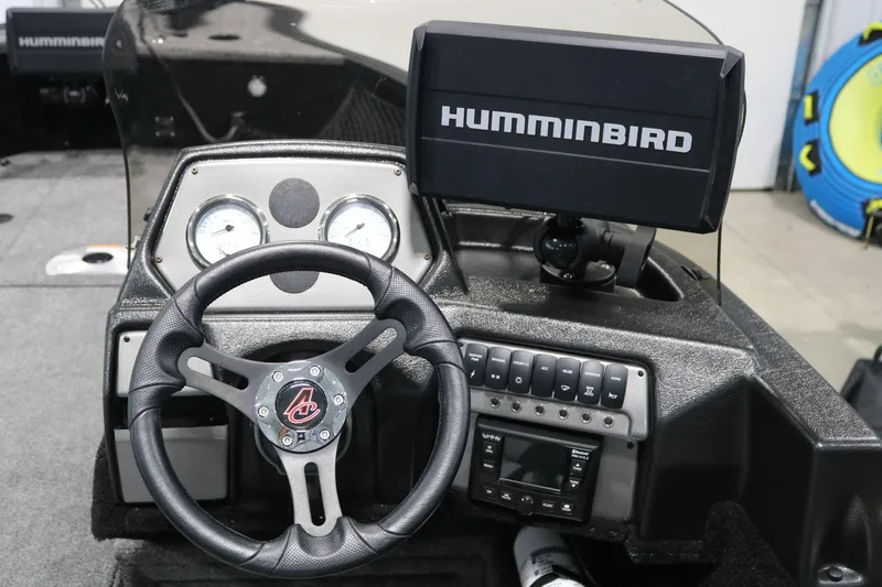 Slide: The Image of 2023 Alumacraft Competitor 185 CS dashboard with steering wheel and Humminbird fish finder. - 17