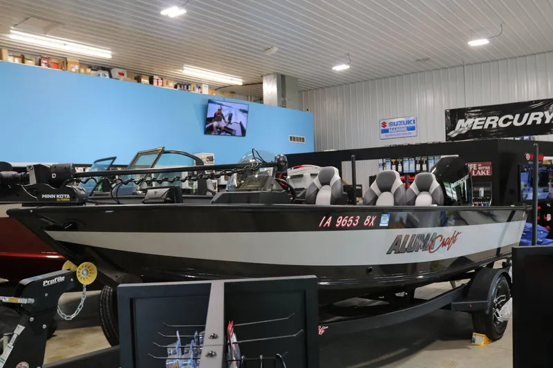 Slide: The Image of 2023 Alumacraft Competitor 185 CS boat displayed in a showroom with accessories. - 3