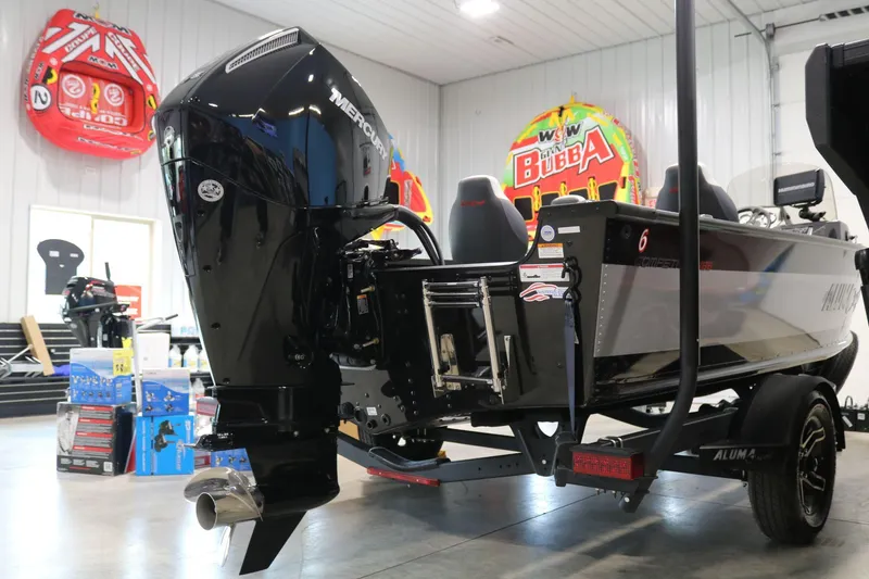 Slide: The Image of 2023 Alumacraft Competitor 185 CS boat with Mercury outboard motor in a showroom. - 4