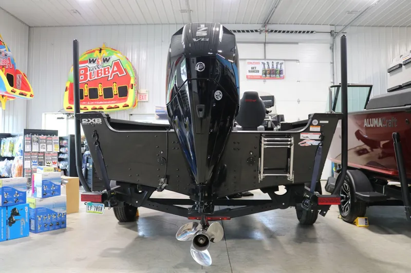 Slide: The Image of 2023 Alumacraft Competitor 185 CS boat in showroom, rear view with motor and accessories. - 5