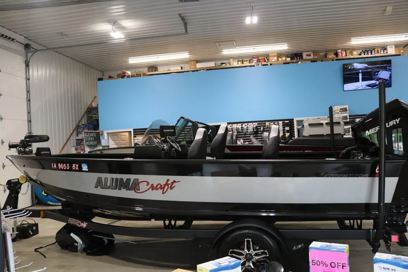 Slide: The Image of 2023 Alumacraft Competitor 185 CS boat displayed in a showroom with promotional signage. - 7