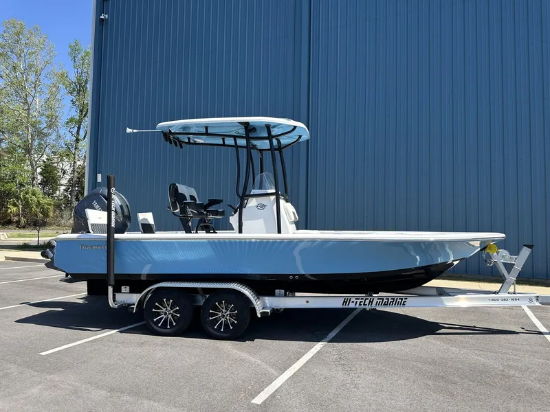 Slide: The Image of 2025 Tidewater 2110 Bay Max boat on trailer, parked outdoors near blue building. - 5
