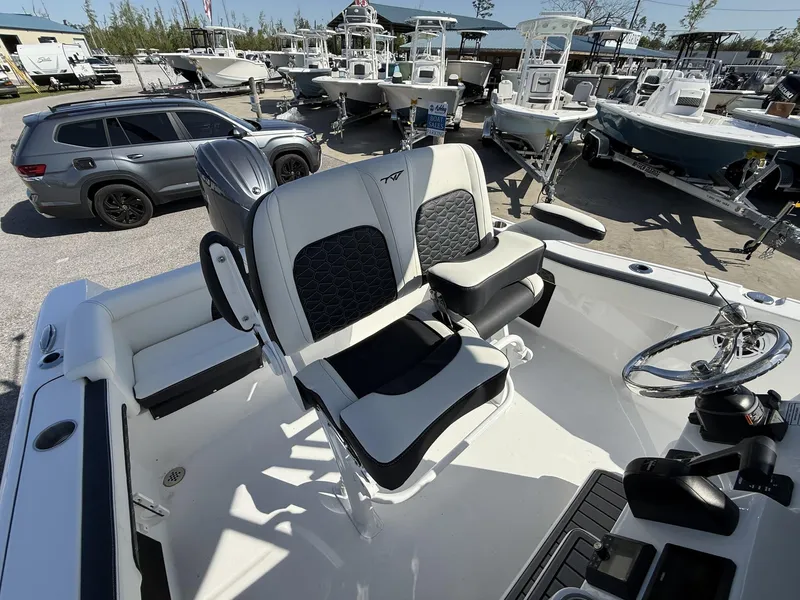 Slide: The Image of 2025 Tidewater 220 LXF boat interior with dual seats and steering wheel, displayed at a dealership. - 10