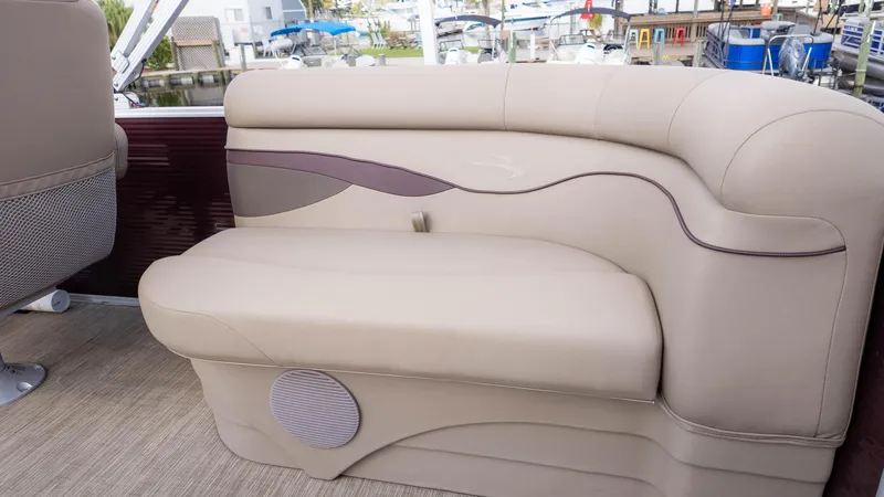 Slide: The Image of 2024 Bennington 20SSR boat interior seating with beige upholstery and speaker. - 11