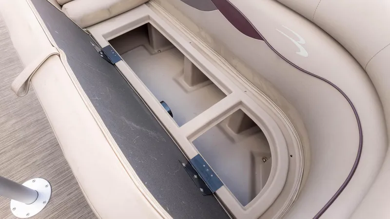 Slide: The Image of 2024 Bennington 20SSR boat storage compartment with open seat revealing spacious interior. - 17