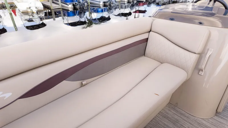 Slide: The Image of 2024 Bennington 20SSR boat interior with beige cushioned seating and quilted design. - 18