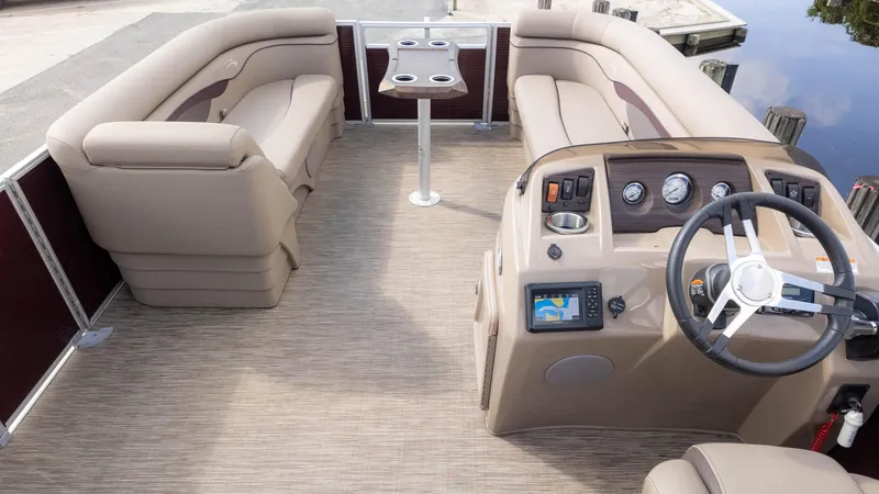 Slide: The Image of 2024 Bennington 20SSR pontoon boat interior with beige seating and modern dashboard. - 8