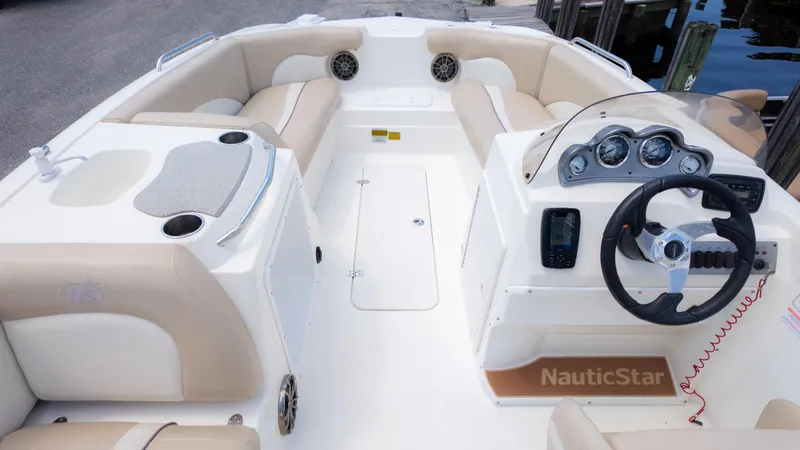Slide: The Image of 2017 NauticStar 203 SC boat interior with beige seating and modern dashboard. - 10