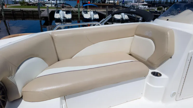 Slide: The Image of 2017 NauticStar 203 SC boat interior with beige seating at a marina. - 24