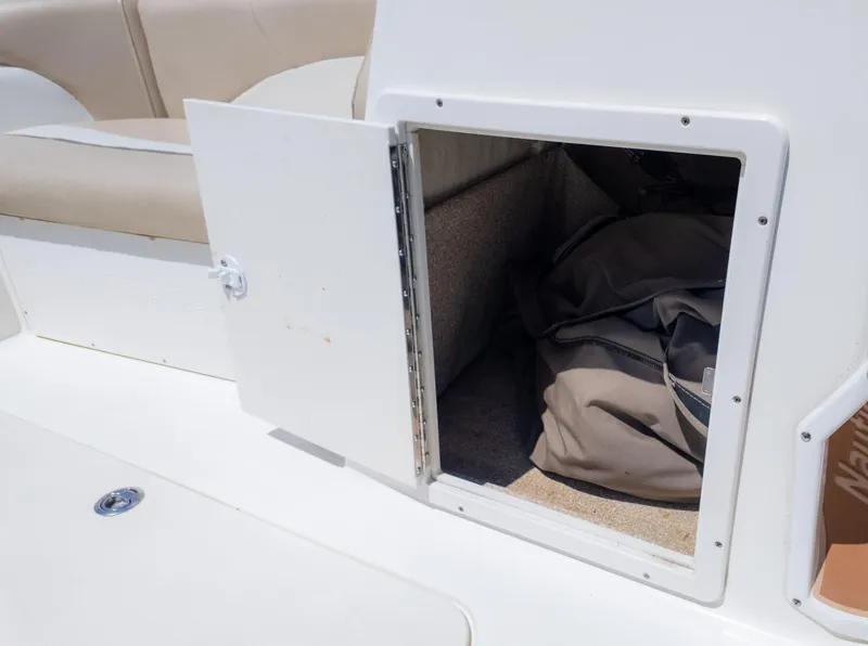 Slide: The Image of Open storage compartment on 2017 NauticStar 203 SC boat, showing interior space and stored items. - 26