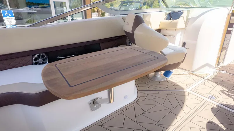 Slide: The Image of Interior of 2015 Regal 2500 boat with wooden table and cushioned seating. - 14