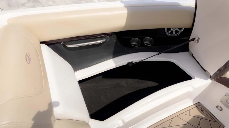 Slide: The Image of Interior of a 2015 Regal 2500 boat, featuring beige seating and storage compartment. - 22