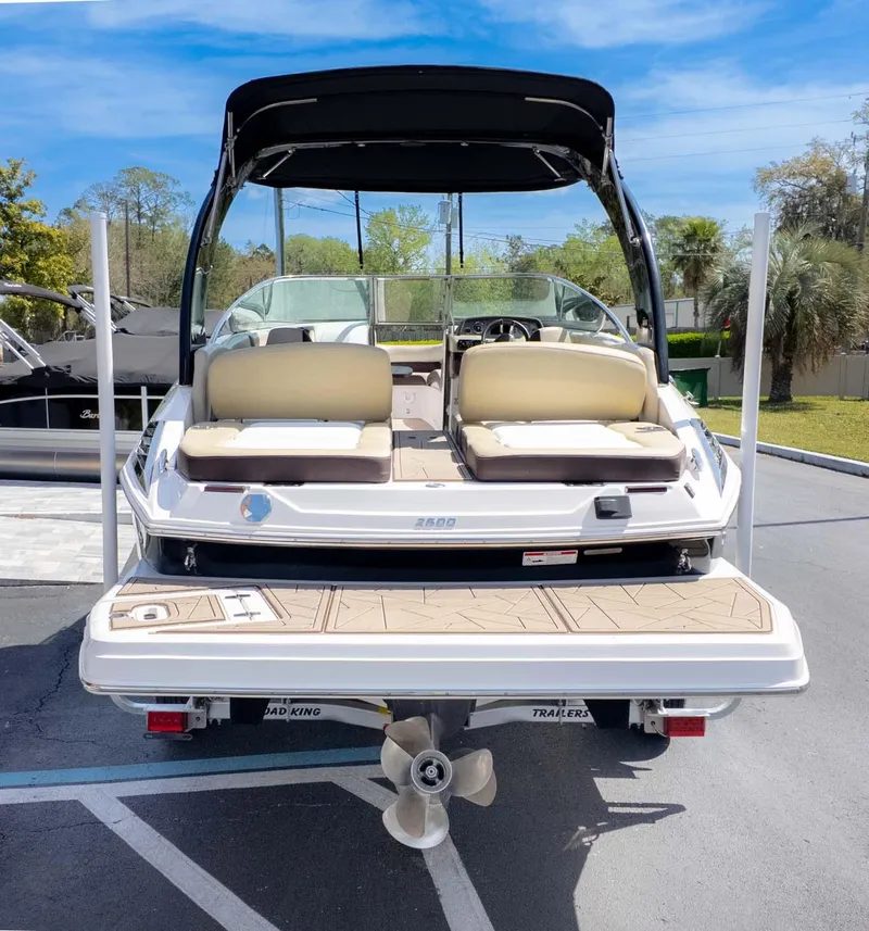 Slide: The Image of 2015 Regal 2500 boat with beige seating and black canopy, parked outdoors. - 5