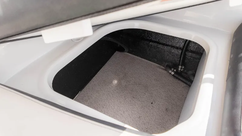 Slide: The Image of Storage compartment of 2021 Stingray 192SC boat, featuring carpeted interior and visible wiring. - 12