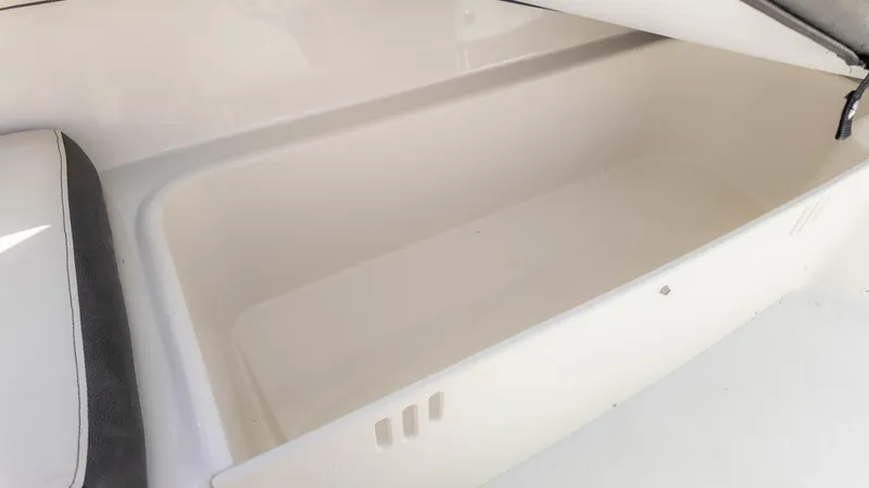 Slide: The Image of Open storage compartment in 2021 Stingray 192SC boat, featuring white interior. - 13