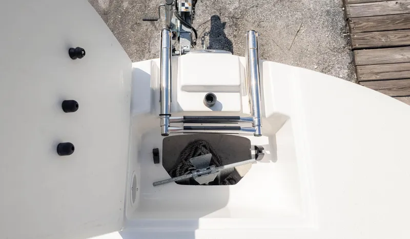 Slide: The Image of 2021 Stingray 192SC boat anchor compartment with ladder and dock view. - 17