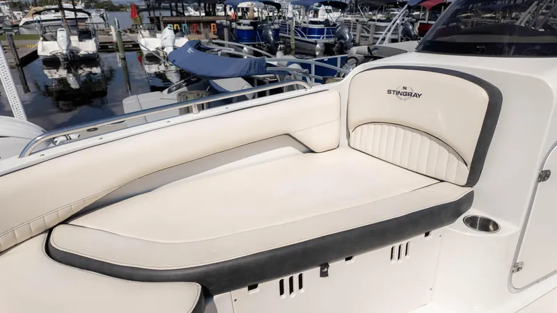 Slide: The Image of 2021 Stingray 192SC boat interior with cushioned seating at a marina. - 18