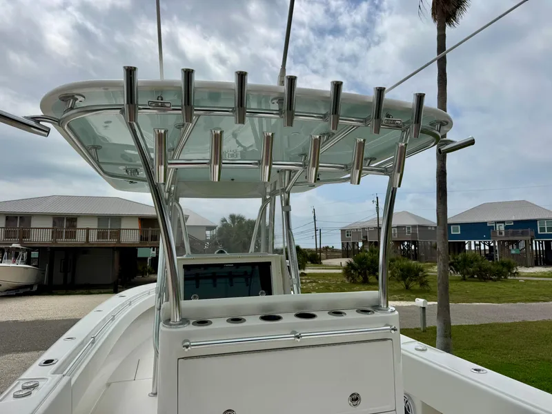 Slide: The Image of 2023 Contender 35ST boat with rod holders and T-top, docked near coastal homes. - 13