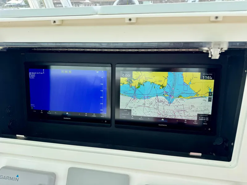 Slide: The Image of 2023 Contender 35ST boat dashboard with dual navigation screens displaying sonar and map. - 16