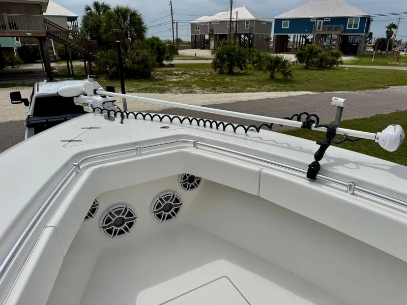 Slide: The Image of 2023 Contender 35ST boat bow with speakers and trolling motor, parked near coastal homes. - 21