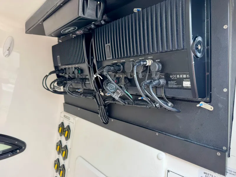 Slide: The Image of 2023 Contender 35ST boat electronics panel with wiring and control switches. - 26