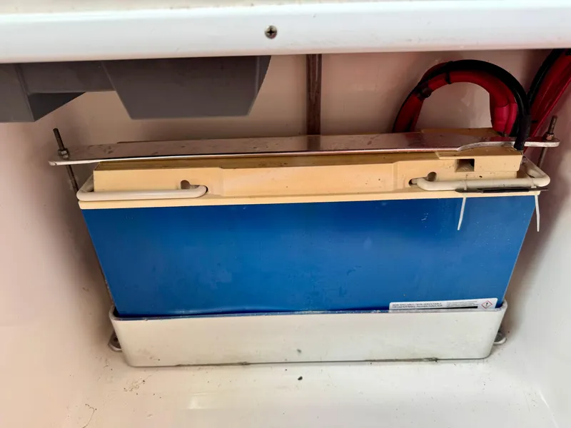 Slide: The Image of Battery compartment of 2023 Contender 35ST boat, featuring a secured blue battery. - 27