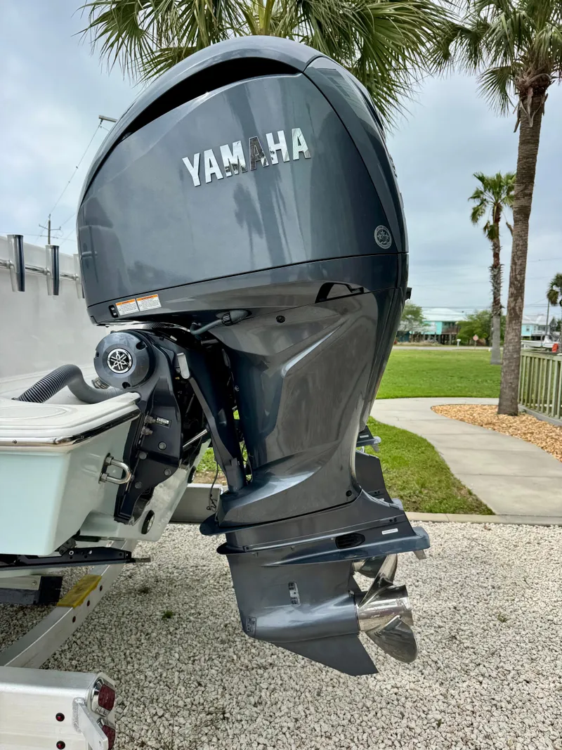 Slide: The Image of 2023 Contender 35ST with Yamaha outboard motor, parked on gravel near palm trees. - 5