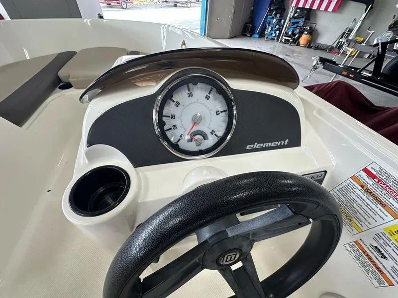 Slide: The Image of 2017 Bayliner Element 18 dashboard with speedometer and steering wheel in a garage setting. - 10