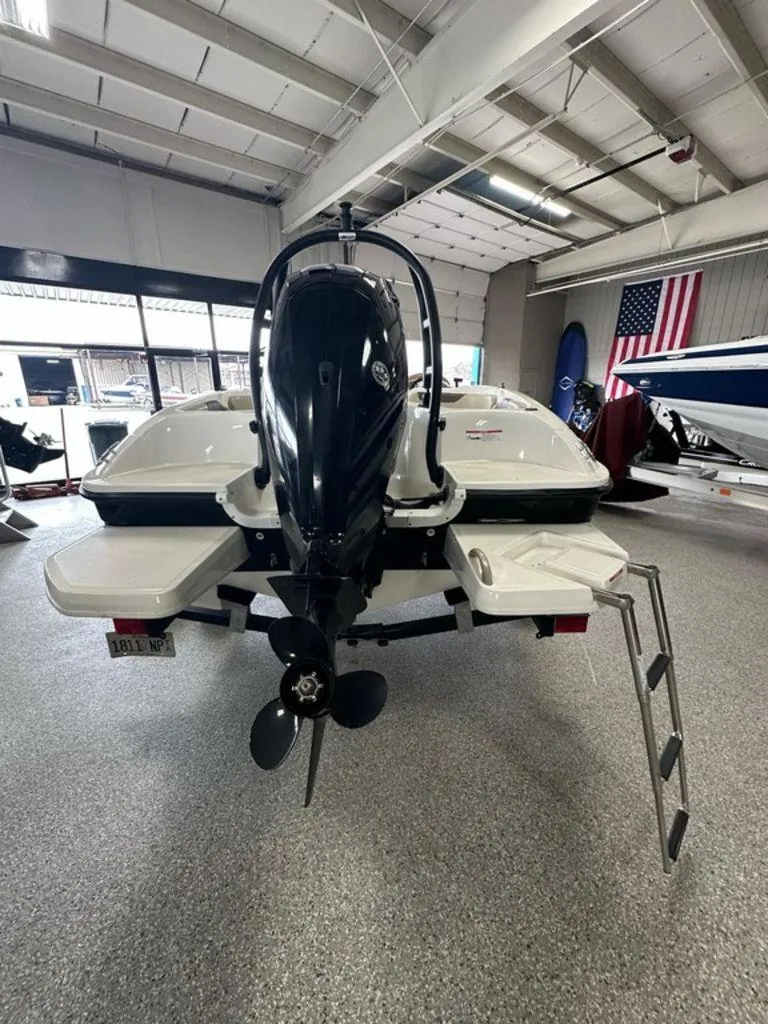 Slide: The Image of 2017 Bayliner Element 18 boat in showroom, rear view with outboard motor and ladder. - 15