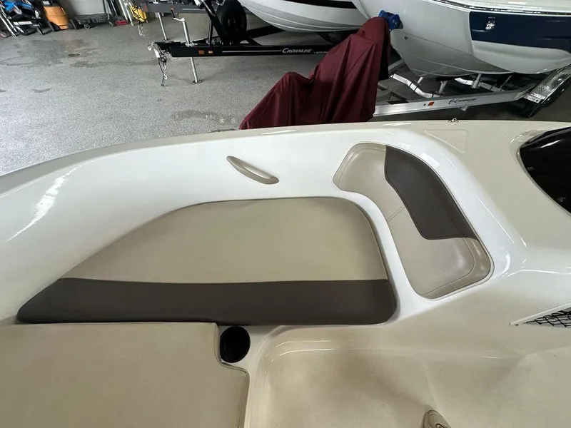 Slide: The Image of 2017 Bayliner Element 18 boat interior with beige and gray seating in a showroom. - 4