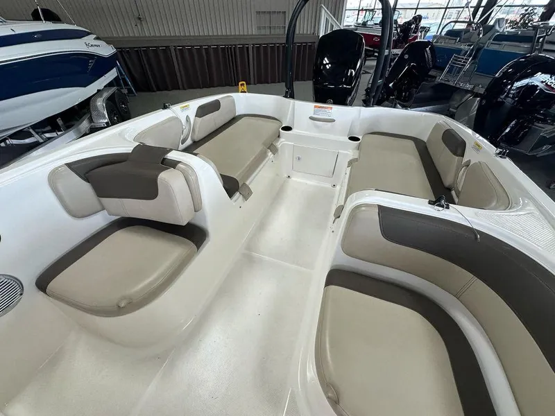 Slide: The Image of 2017 Bayliner Element 18 boat interior with beige and brown seating in a showroom. - 8