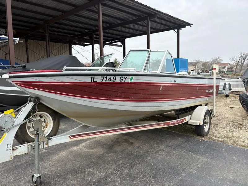 Slide: The Image of 1988 Crestliner Nordic 18 boat on trailer, red and silver, parked under shelter. - 1