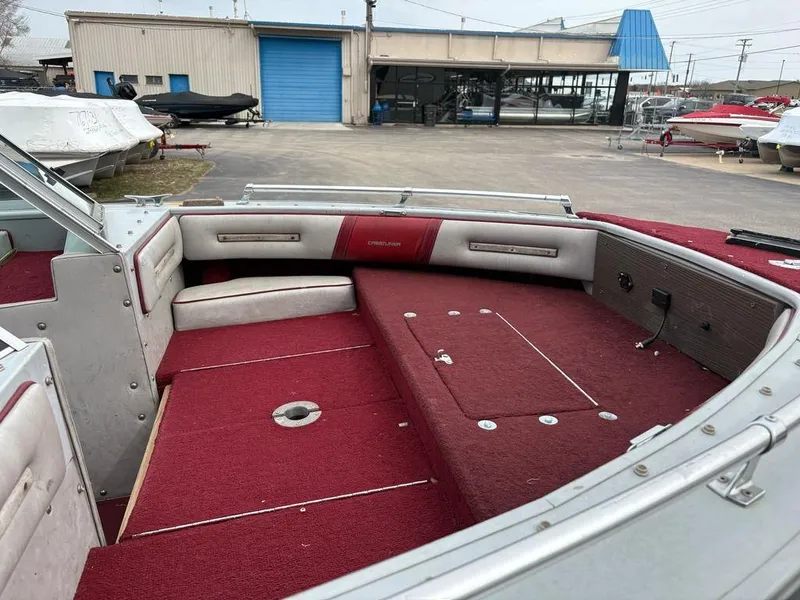 Slide: The Image of 1988 Crestliner Nordic 18 boat interior with red carpet and seating, parked near a showroom. - 4