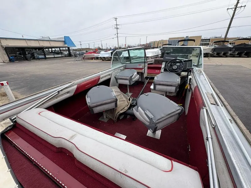 Slide: The Image of 1988 Crestliner Nordic 18 boat interior with red and gray seating, parked outdoors. - 6