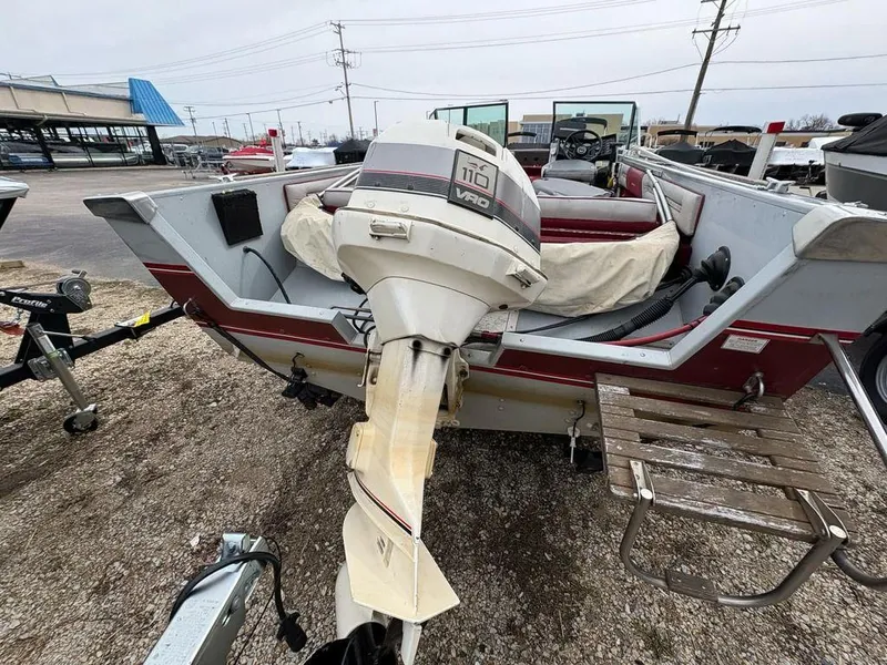 Slide: The Image of 1988 Crestliner Nordic 18 boat with outboard motor, parked on gravel lot. - 7