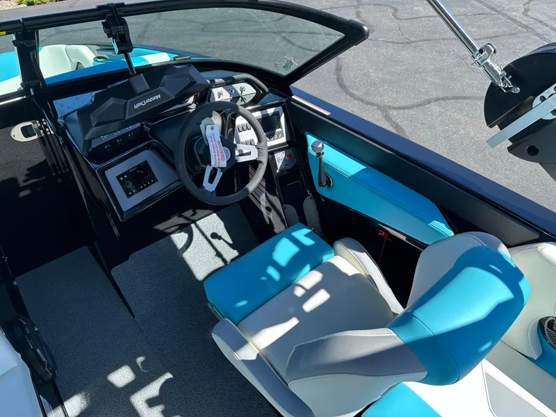 Slide: The Image of 2022 MasterCraft NXT20 boat interior with blue and white seating, modern dashboard, and steering wheel. - 11